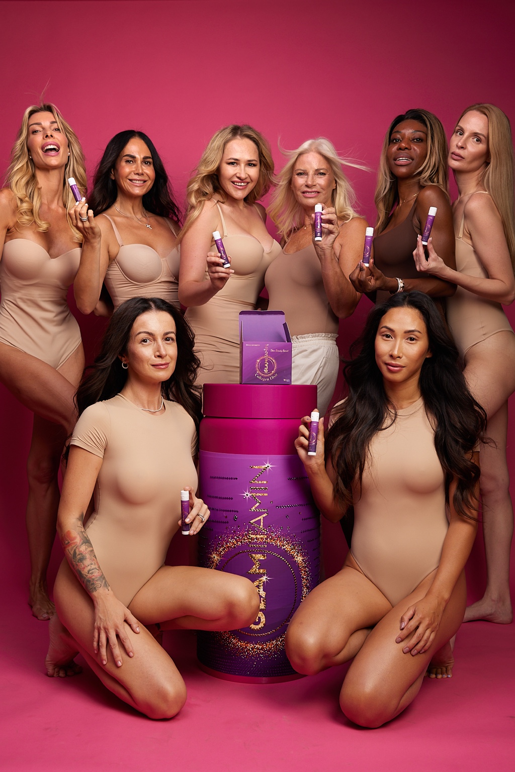 Gruppenportrait mit Produkten vor pinkfarbenem Hintergrund