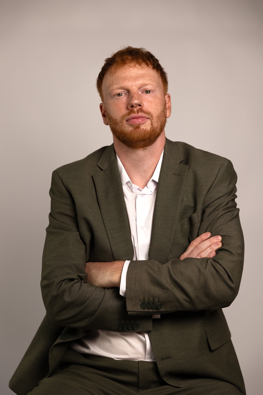 Studioportrait eines Mannes im olivgrünen Anzug